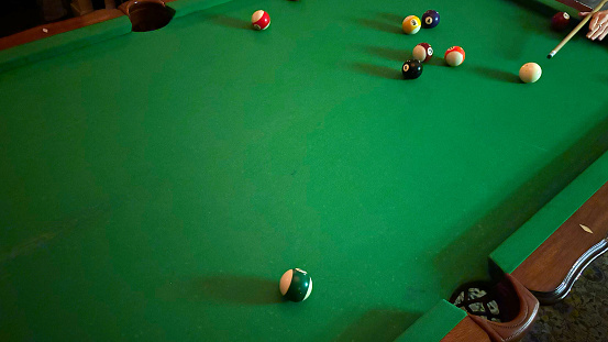 Hand of a Woman Preparing to Strike Pool Balls with Cue Stick on Pool Table
