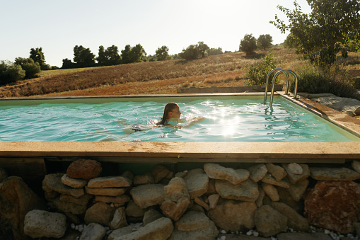 Photo of a young woman swimming in the pool
