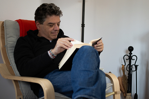 Man reading a book and sitting quietly in a chair