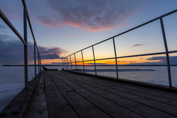 istock Abandoned broken pier is under sunset sky on a winter evening 2097162812