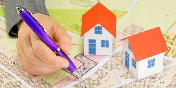 istock Engineer drawing over an imaginary cadastral map of territory and General Urban Planning with buildings, roads and land parcel - Building activity concept 2097164992