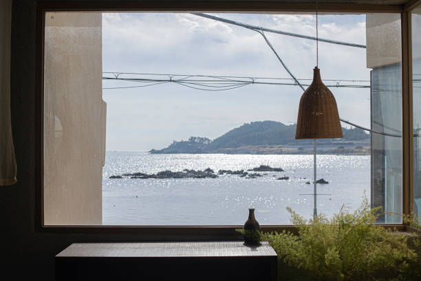 istock Rattan pendant lights over wooden table with ocean view 2097166593