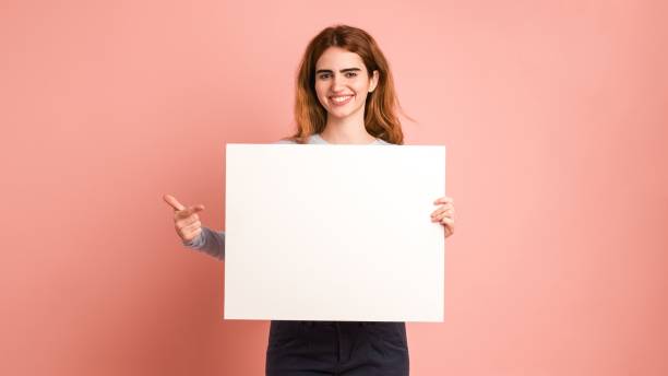 istock Happy woman showing free copy space on blank empty placard 2097170799