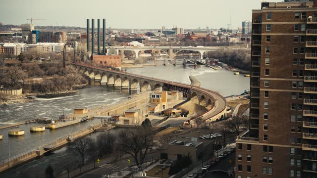 telephoto clip of the iconic Stone Arch Bridge in downtown Minneapolis shot from the window of a high rise condominium