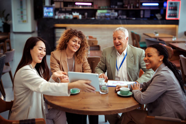 istock Young beautiful well dressed woman presenting new project to her colleagues while using digital tablet at the restaurant 2097189849