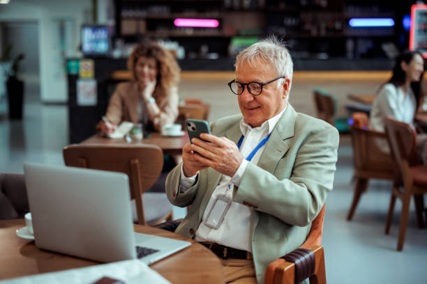 istock Senior businessman text messaging at restaurant 2097191929