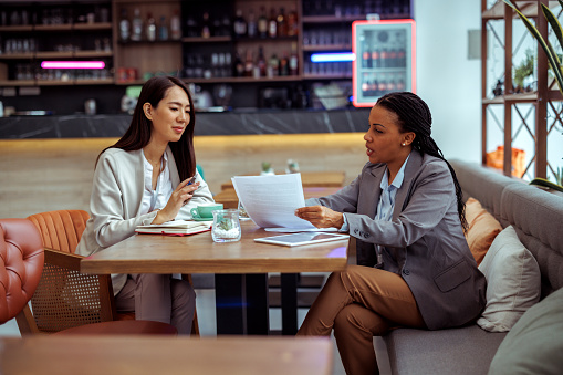 Two well dressed businesswomen working at cafe