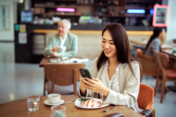istock Smiling well dressed businesswoman text messaging from cafe 2097204318