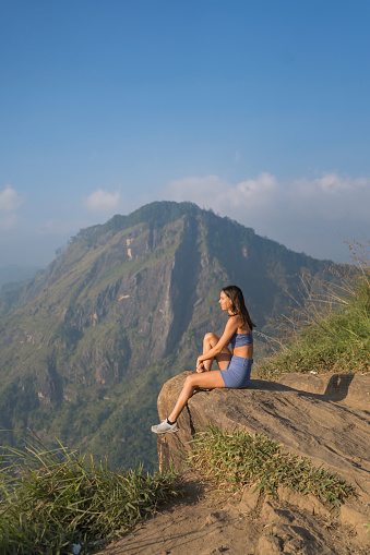 Young woman on top of mountain looks out