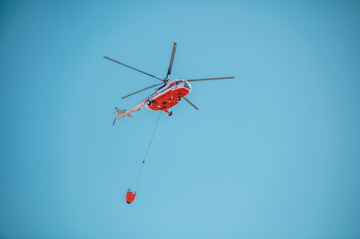 Los Angeles, California, USA - November 10, 2023;  US Coast Guard helicopter lowering a basket to a Los Angeles County Lifeguard boat.