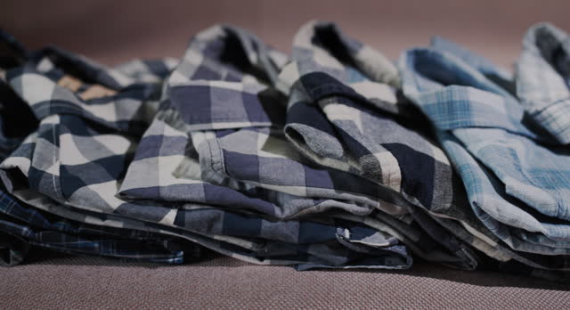 Gently folded shirts lie on the shelf. Slider shot