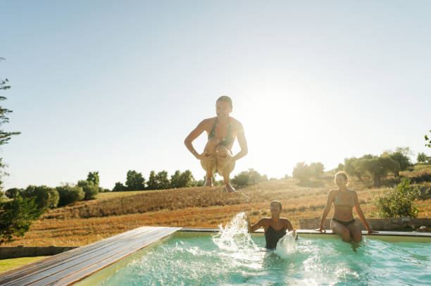 istock Female friends jumping into the pool 2097269315