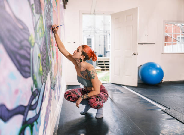 Young Dancer Delivers Captivating Improvised Contemporary Dance Performance, Adorned in Vibrant Neon Body Paint and White Clothes, Against an Abstract Art Background in a Dark Space