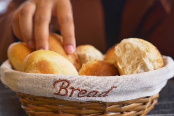 women hand pick baked bun on table .