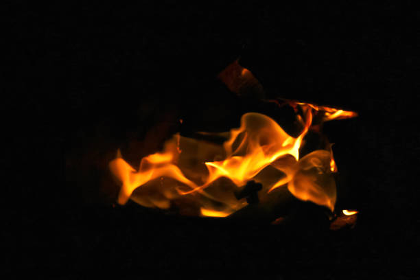 Orange flame fire on black background. Dramatic flames flickering against the darkness. Fire and heat element, danger, intensity, contrast. Out of focus.