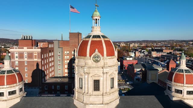 York, Pennsylvania county government building with domes and American flag in background. Aerial shot on autumn evening.