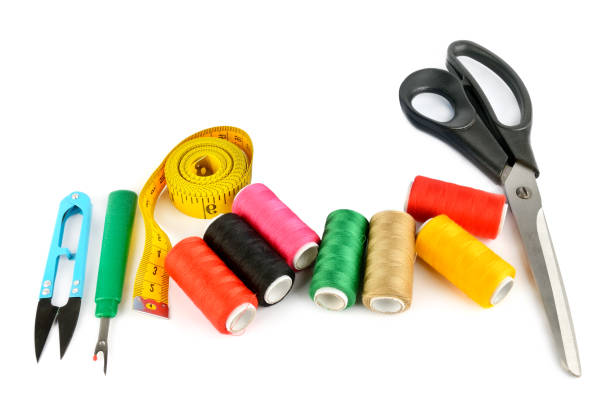 istock Sewing supplies (thread, scissors and measuring tape) isolated on a white . 2097313132