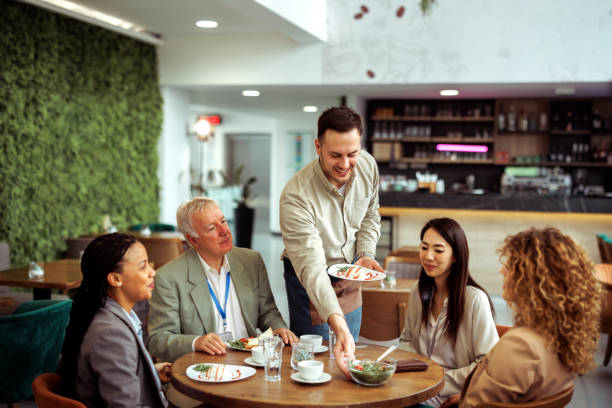 istock Waiter serving lunch for business people at modern restaurant 2097323521