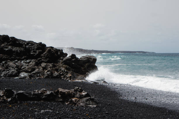 Black beach with black sand and clear blue water at Lanzarote, Canary Islands, Spain