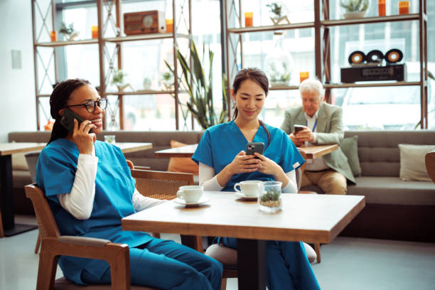 istock Medical workers using their smart phones while having a break at cafeteria 2097327718