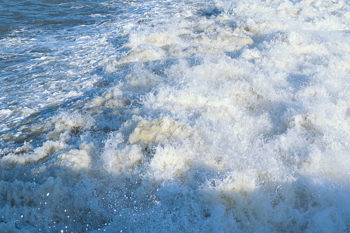 Waves crash on the shore. Splashes of water, drops, splash. Marine background. Beautiful seascape.