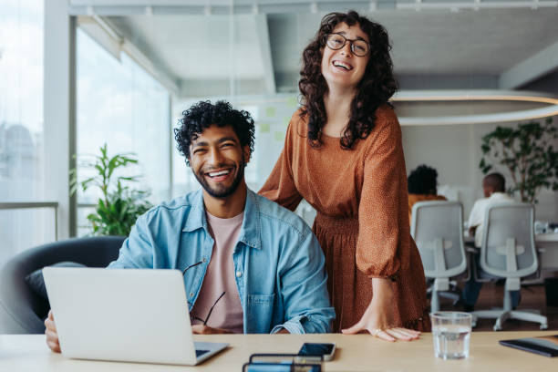 istock Two happy business people working together in a collaborative office environment 2097332428