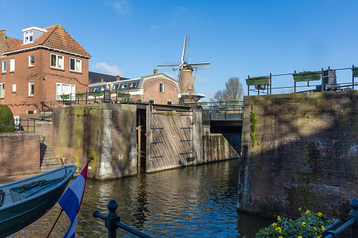 Gorinchem, the Netherlands. 27 February 2024. Windmill with the name “Molen Nooit Volmaakt'' is one of the two flour mills on the ramparts. The mill is still running in the fortified city of Gorinchem