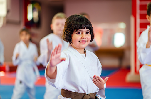 Little  Girl Training During a Karate Class, looking at camera, smiling