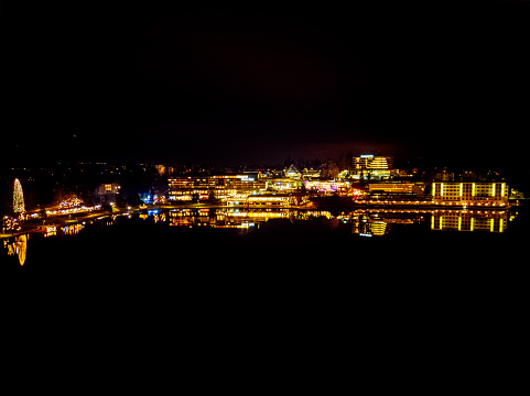 Bled town waterfront hotels at night with reflection on a calm lake surface. Christmas holidays in Slovenia. Date: 19.12.2023, Bled, Slovenia.