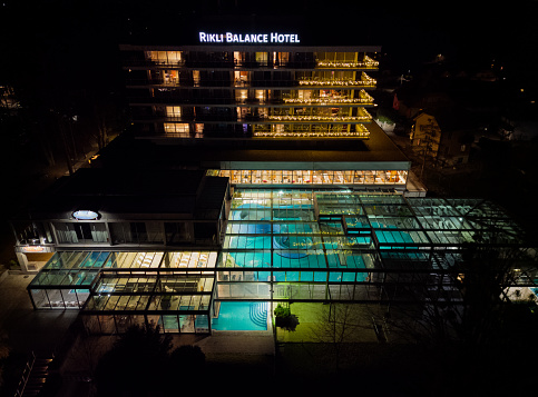 Lake Bled Rikli Balance Hotel at night with illuminated indoor swimming pool