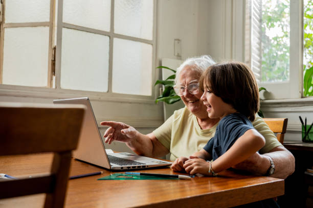 istock Grandmother and grandson using laptop at home 2097423060