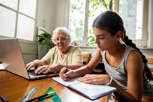 istock Girl doing homework with help from grandmother at home 2097423585