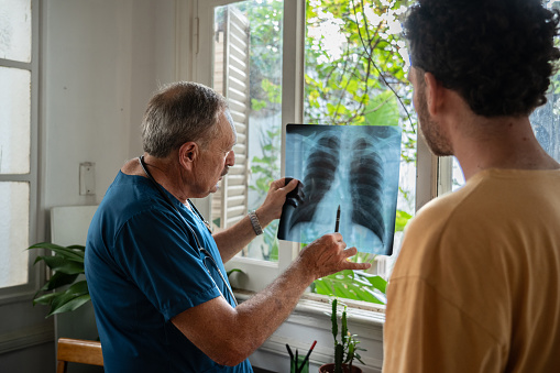 Male nurse explaining x-ray image to patient
