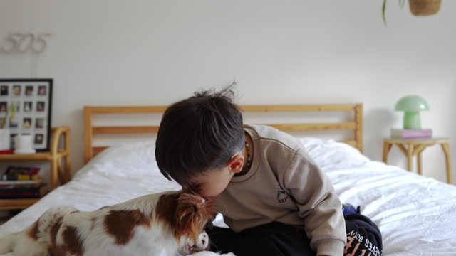 Cute baby boy and his dog enjoying the moment at home
