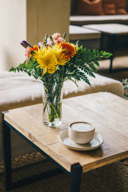 istock Coffee on rustic table with blurred flowers in the background 2097459246