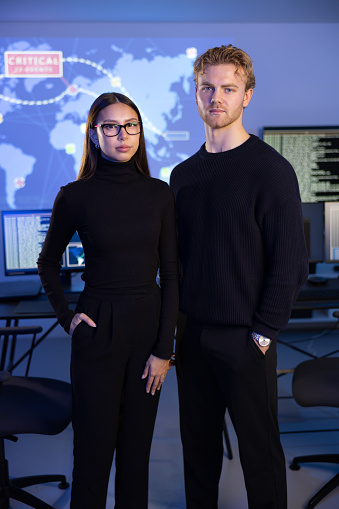 Professional and confident cyber security team (SOC) standing in front of cybersecurity SIEM system with logs and incident map. Analyst and security officer (CISO)