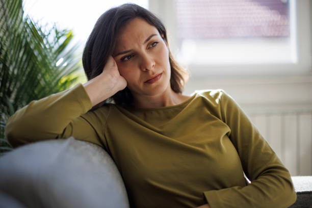 istock Upset woman sitting on couch alone at home 2097483650
