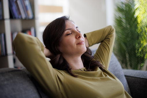 Happy smiling woman relaxing on sofa at home