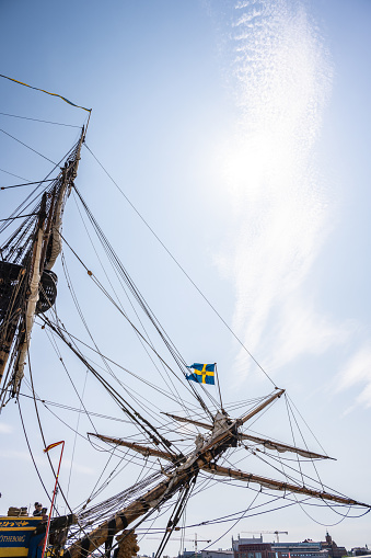 Gothenburg, Sweden - June 03 2023: Swedish flag flyig on a indiaman replica sailship.