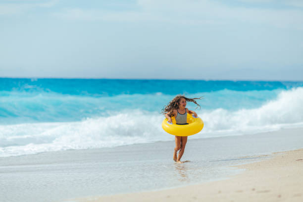 istock Cheerful girl playing with inflatable ring on the beach her summer vacation 2097603942