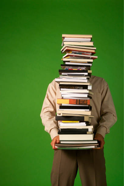 istock man carrying a stack of books, isolated on green background, stacked books, reading concept, space for text 2097606524
