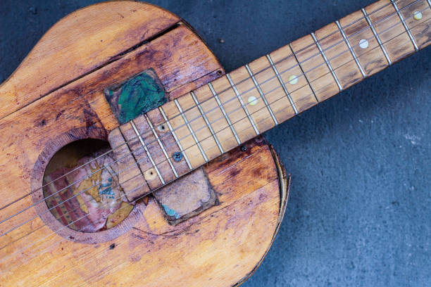 old guitar on concrete wall background with blurred front and back background with bokeh effect - musical instrument string music dark old fashioned zdjęcia i obrazy z banku zdjęć