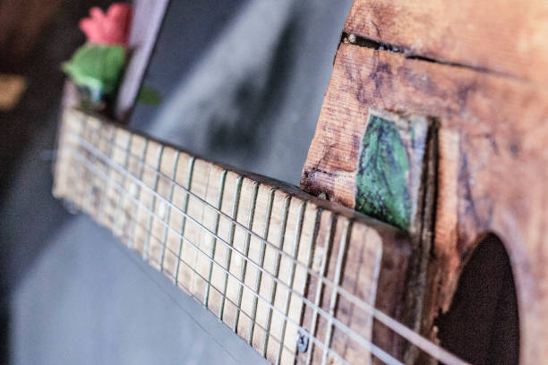 istock old guitar on concrete wall background with blurred front and back background with bokeh effect 2097618670