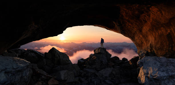 istock Adventure Man standing in rocky cave. 2097644879