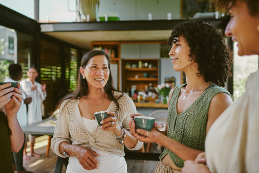 Smiling group of women talking over tea during a wellness retreat together