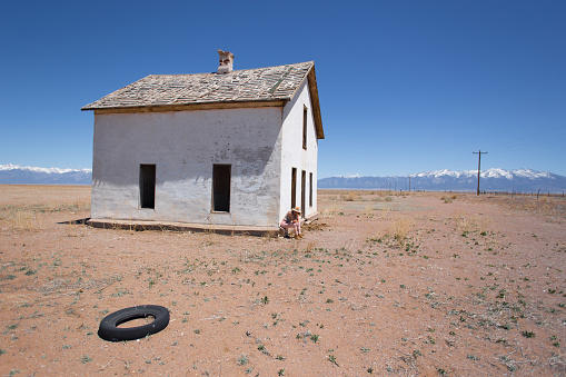 Abandoned White House in Desert, Tire, Woman Sitting