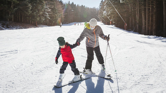 Asian mother and daughter skiing in the mountain.
