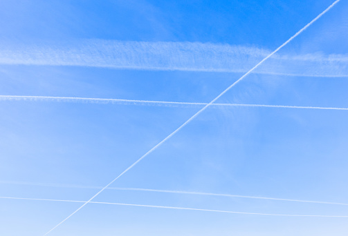 Blue sky filled with multiple contrails