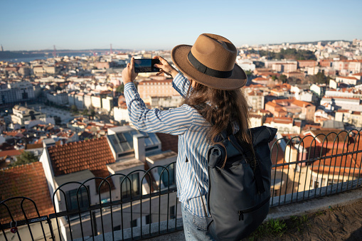 City break. Woman discovers solo Lisbon on vacation, taking photos.