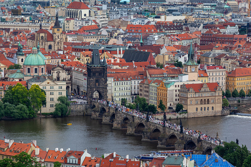 The Charles Bridge (Karluv most), the water clock tower, the old town bridge tower over Vitava river and the large dome of St francis of assisi church in Prague, Czech Republic.